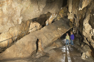 A casually dressed man and woman stand and observe their cave surroundings at Crystal Cave.