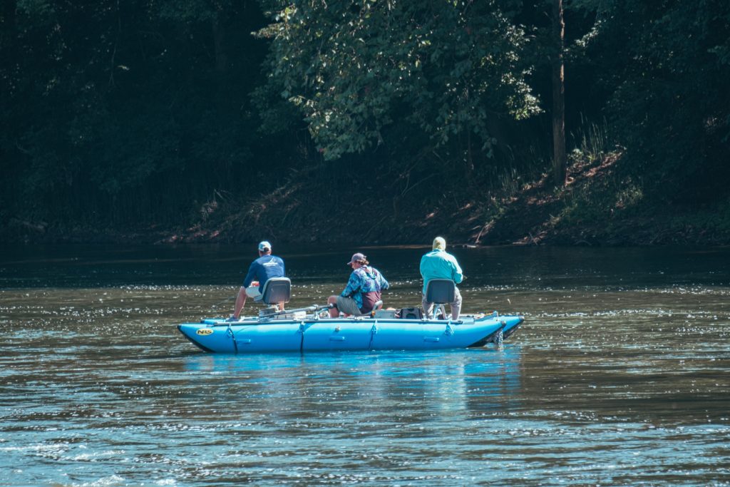 three men on raft in river